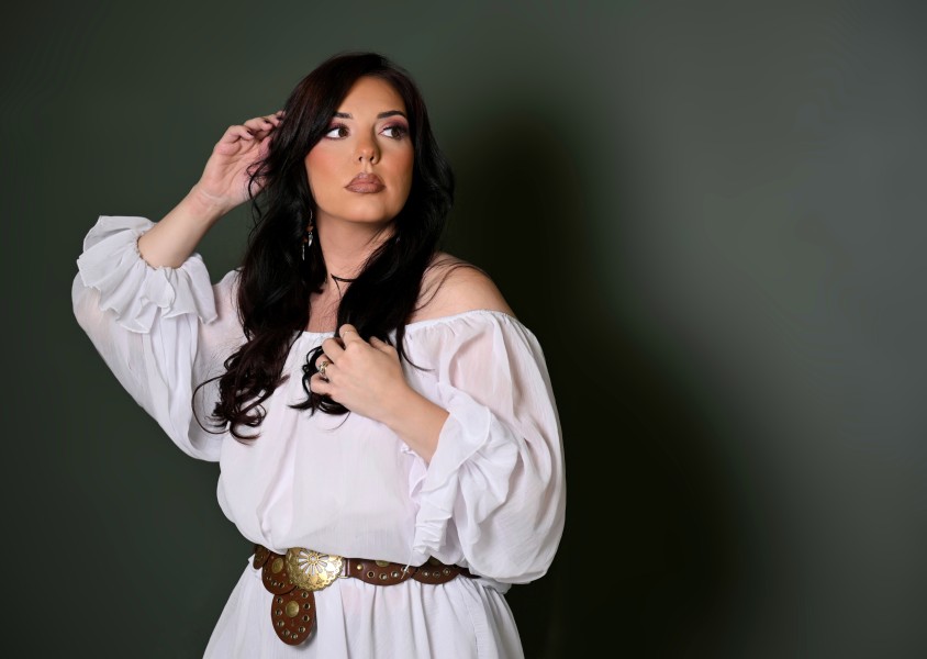 Woman in white dress against green wallx